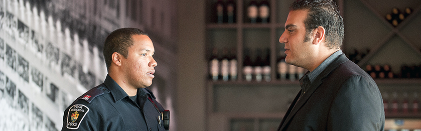 An officer talks to a man in a suit